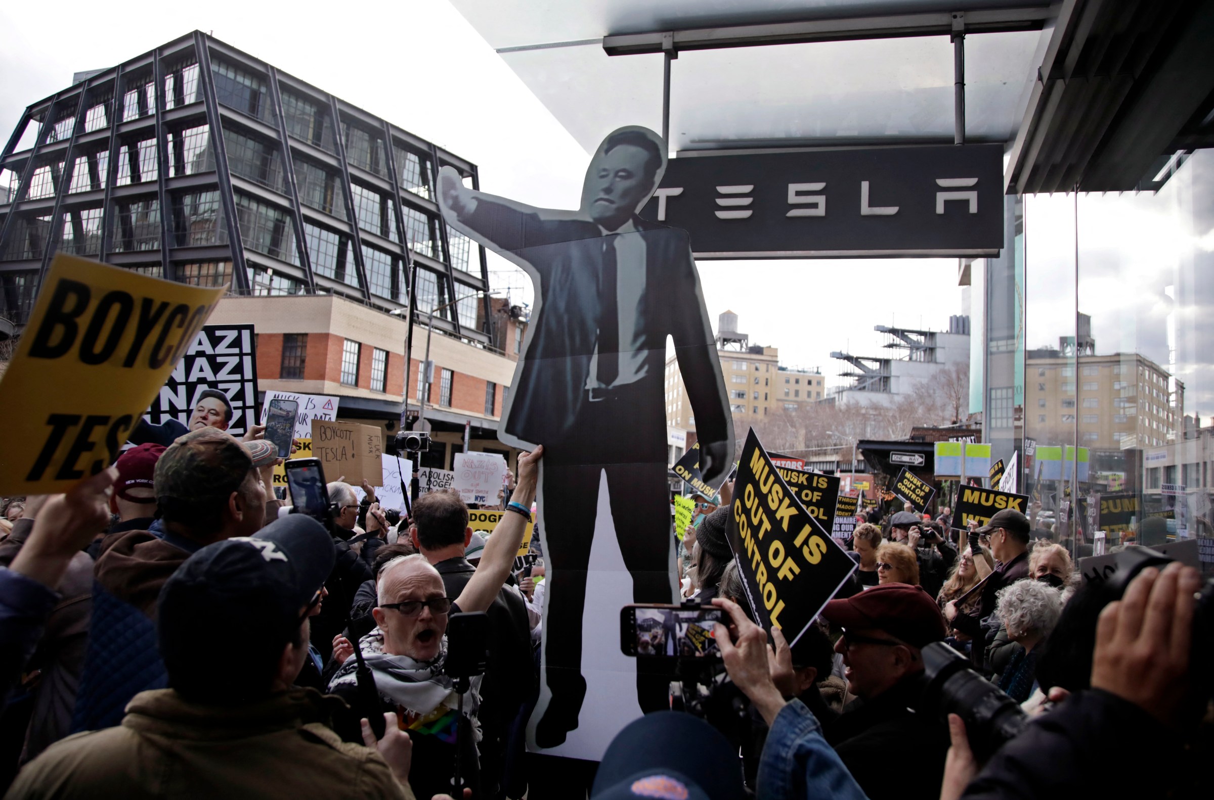 People participate in a “TeslaTakedown” protest against Elon Musk outside of a Tesla dealership in New York, March 1, 2025. (Photo by Leonardo Munoz / AFP) (Photo by LEONARDO MUNOZ/AFP via Getty Images)