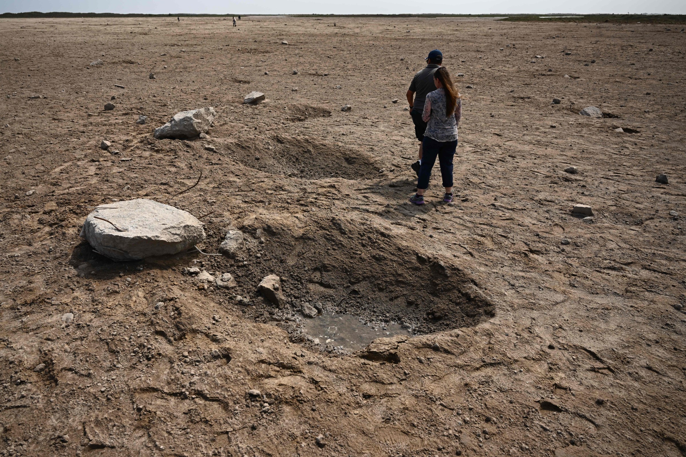 Members of the public walk through a debris field at the launch pad on April 22, 2023, after the SpaceX Starship lifted off on April 20 for a flight test from Starbase in Boca Chica, Texas.