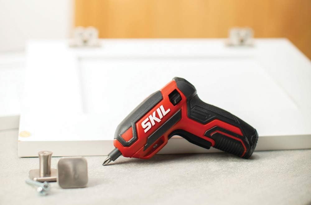 Electric screwdriver with hand grip on top of table.