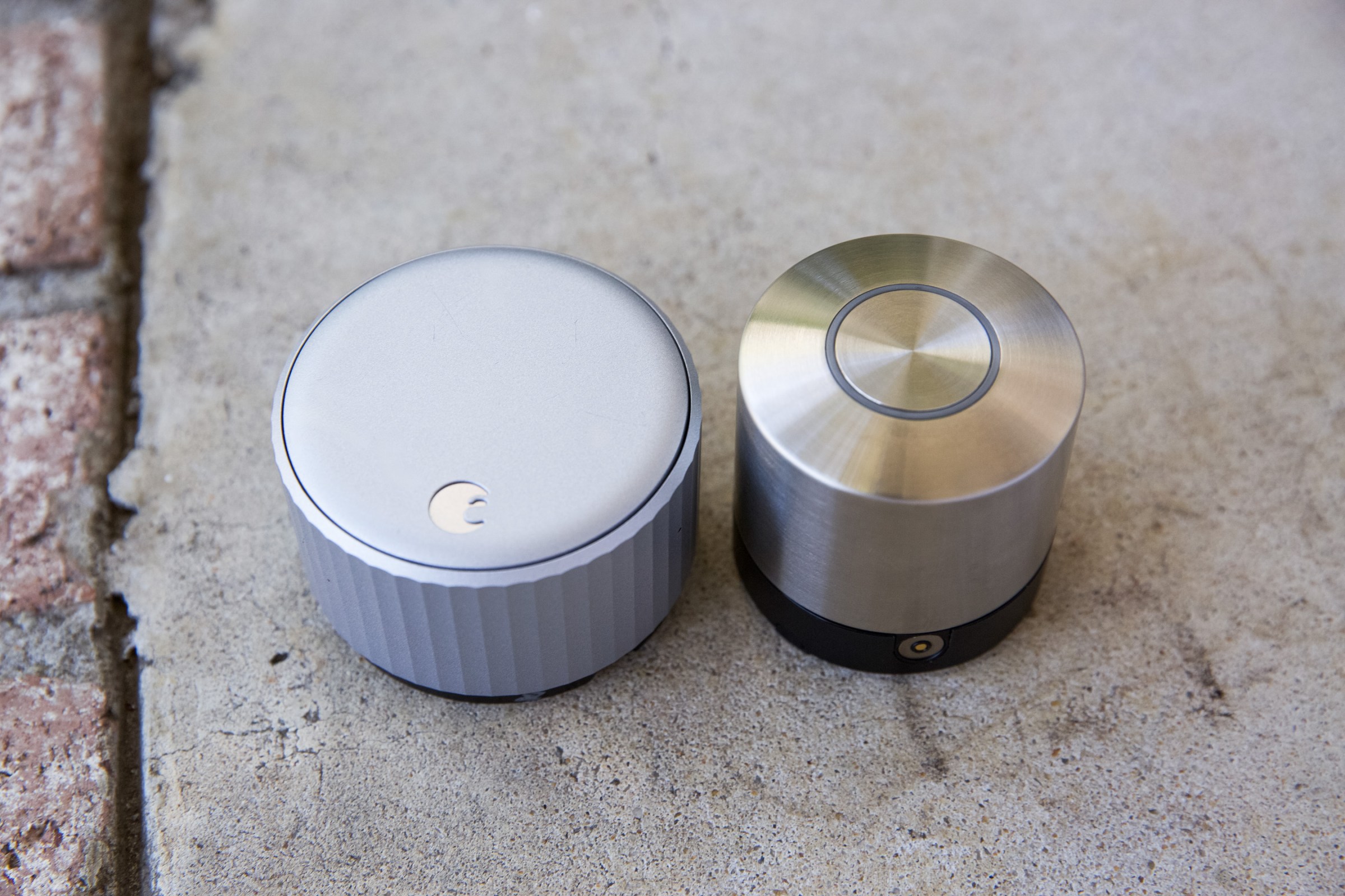 The August smart lock next to the Nuki. At 2.2 inches in diameter, the Nuki is a quarter of an inch taller but almost an inch slimmer.