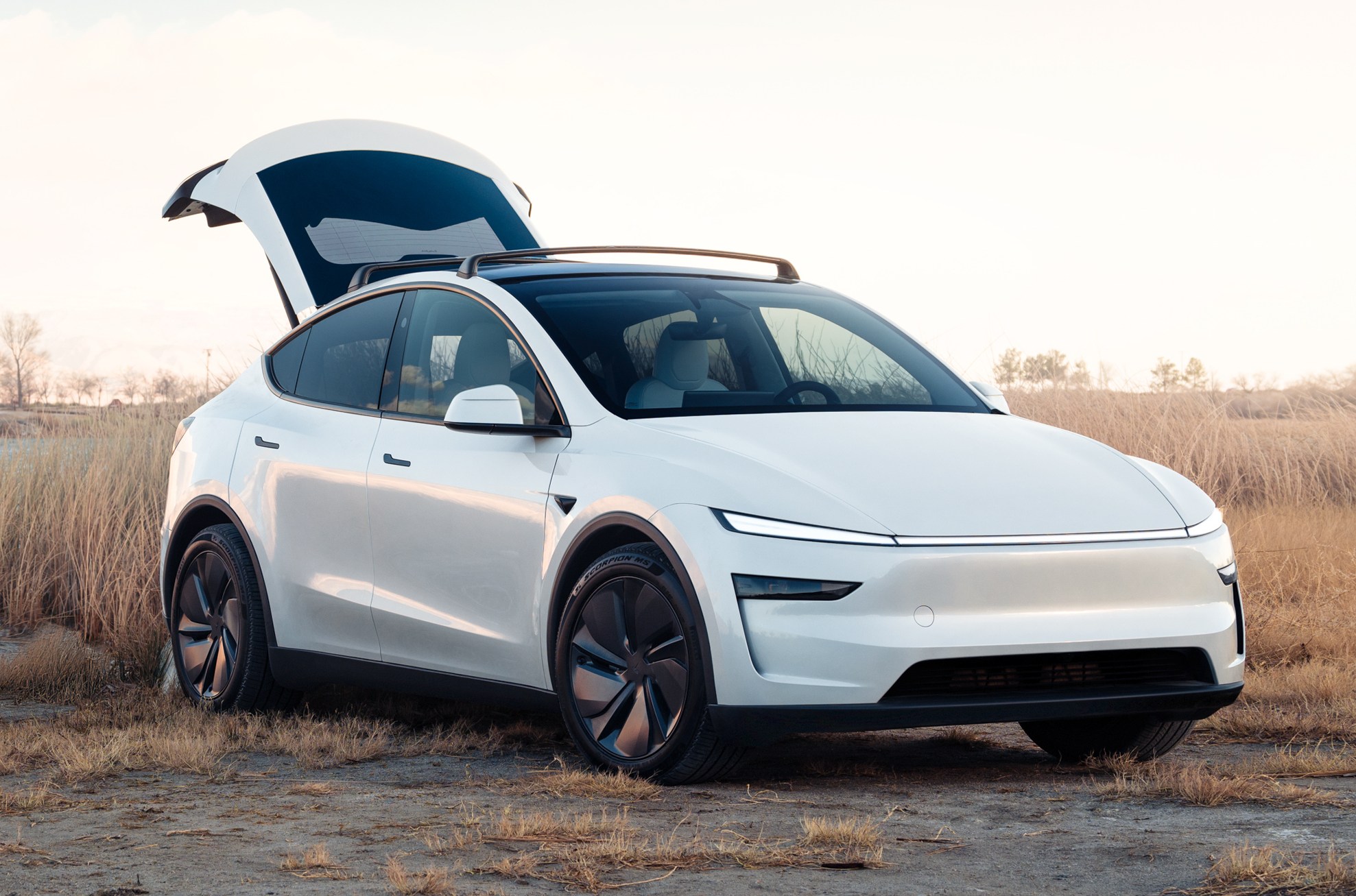 A new Tesla Model Y in white with the trunk raised.
