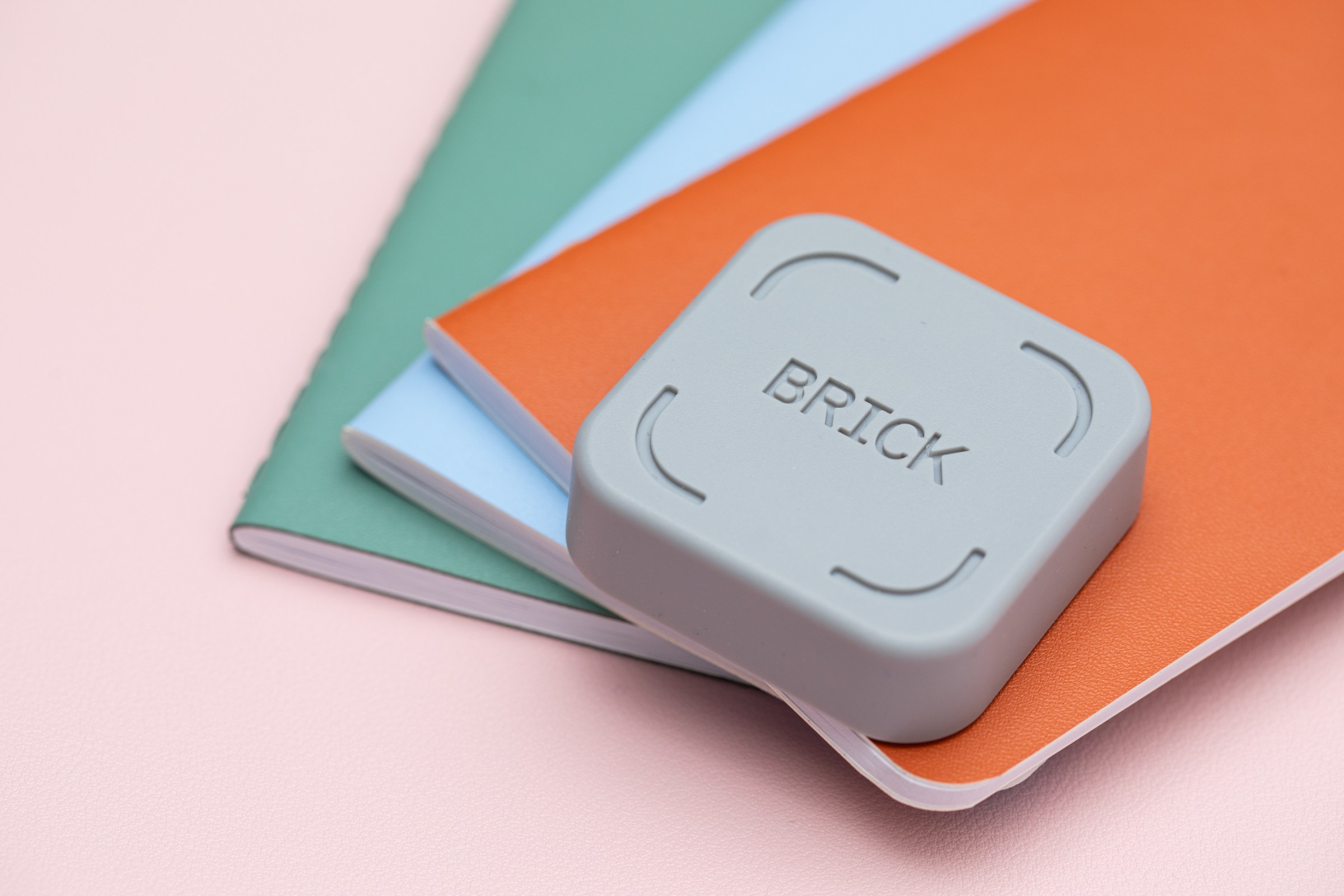 the Brick key on top of three colorful notebooks.
