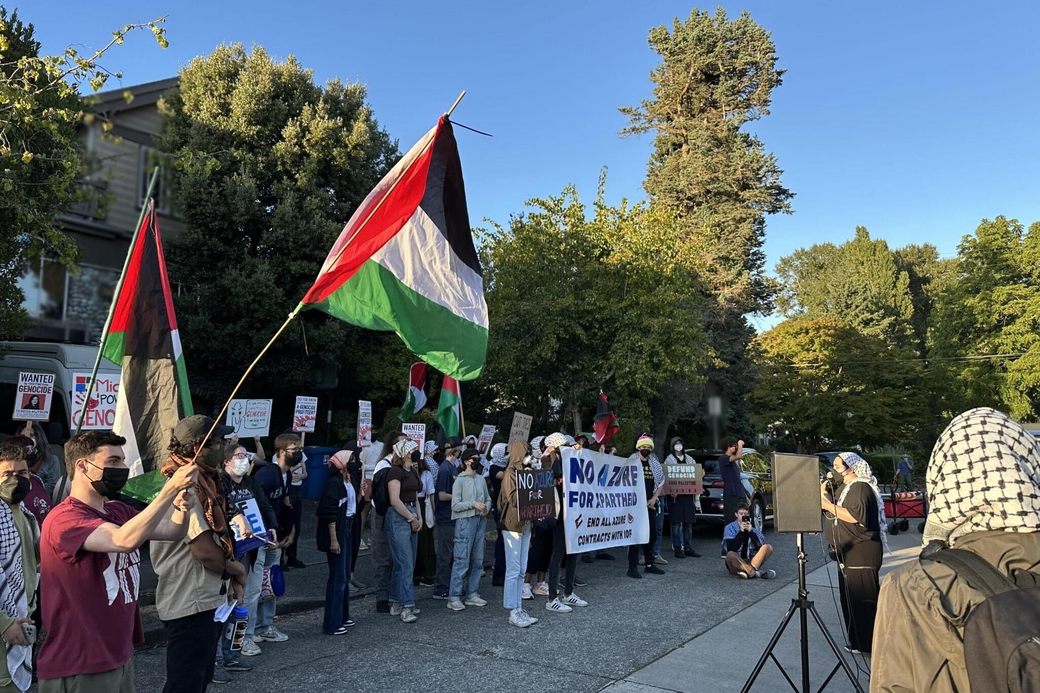 Protesters also carried wanted signs and banners (blurred to remove identifying details).