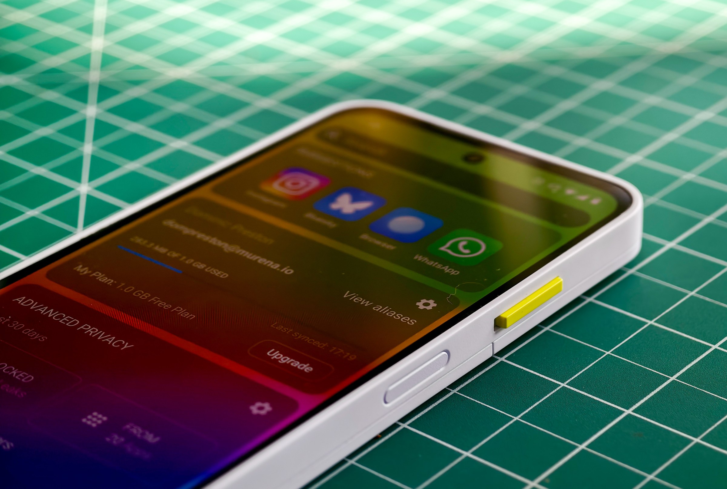 Photo of the Fairphone 6 lying on a green cutting mat with a closeup on the side key