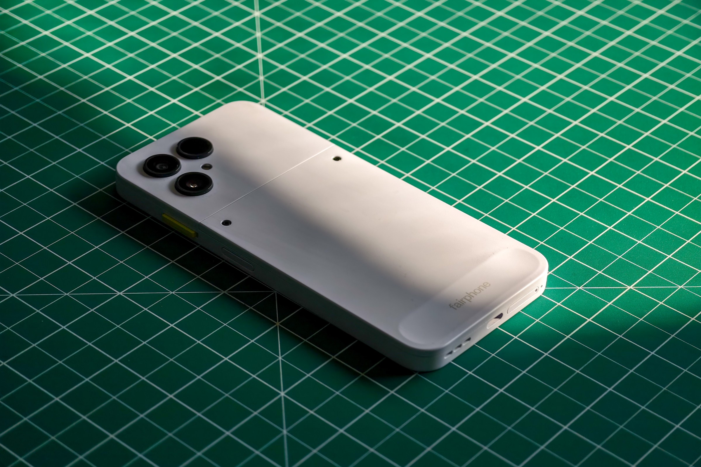 Photo of the Fairphone 6 lying on a green cutting mat