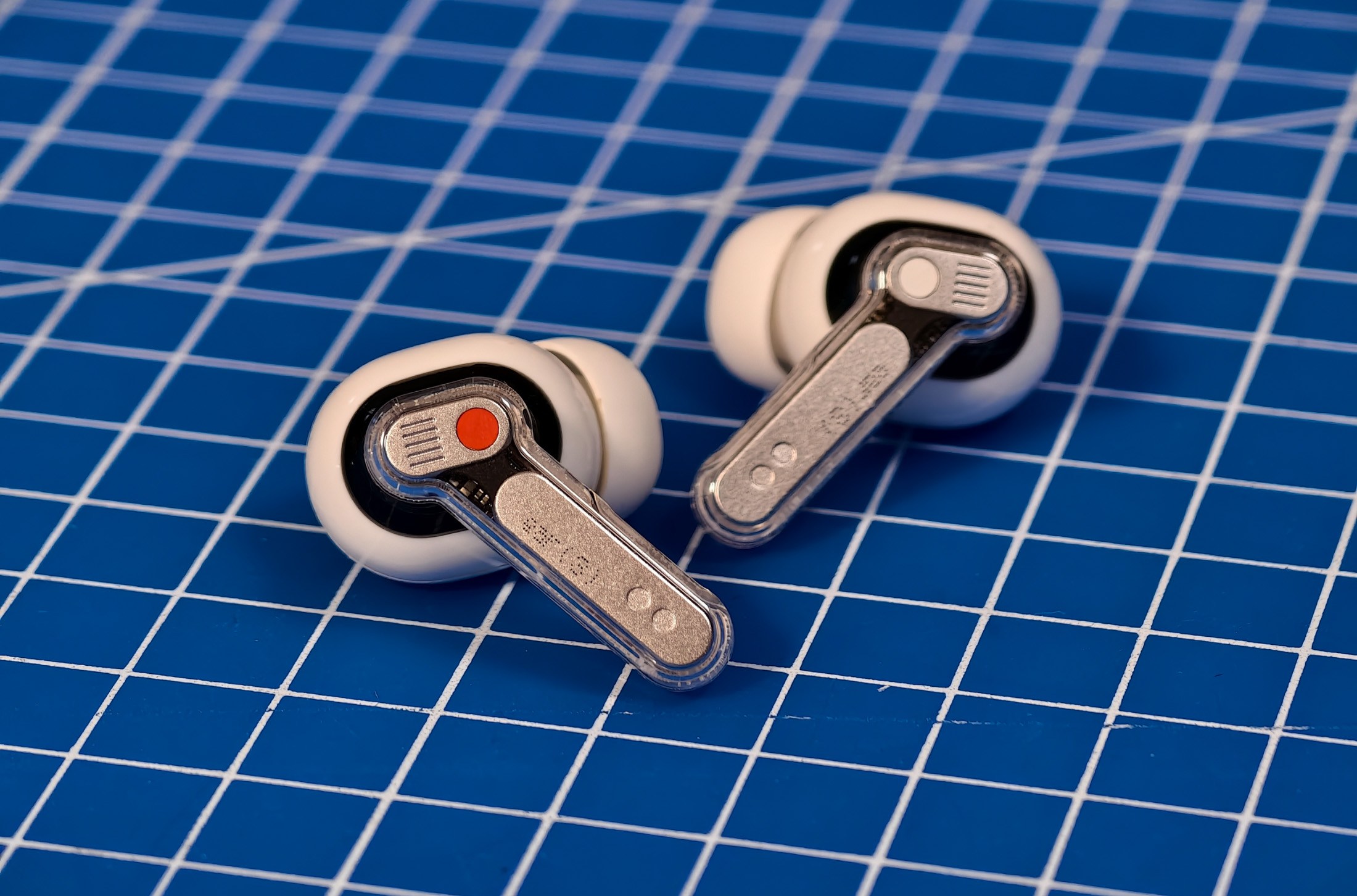 Nothing Ear 3 buds lying on a blue mat.