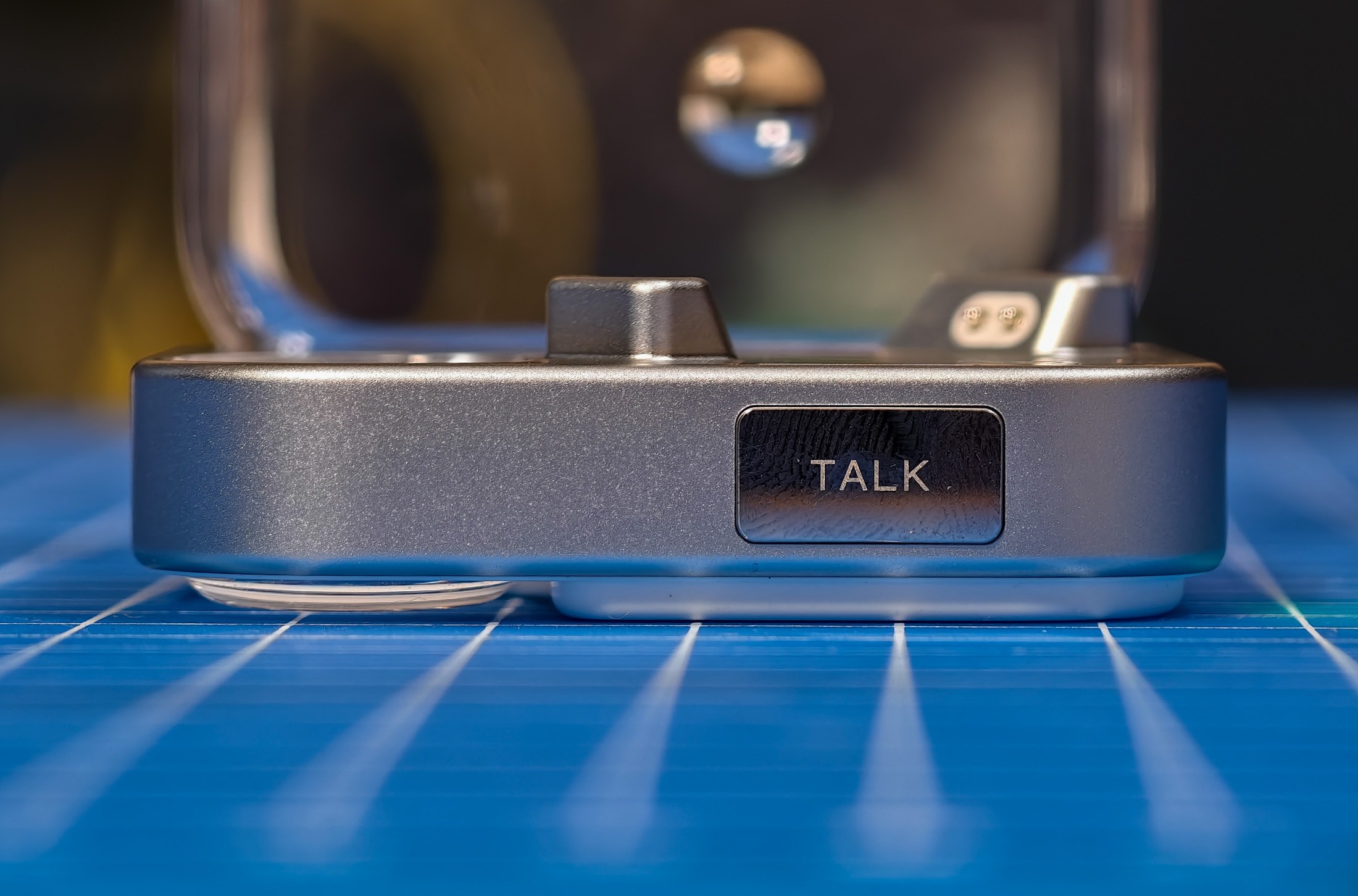 Nothing Ear 3 charging case from a side view on a blue mat