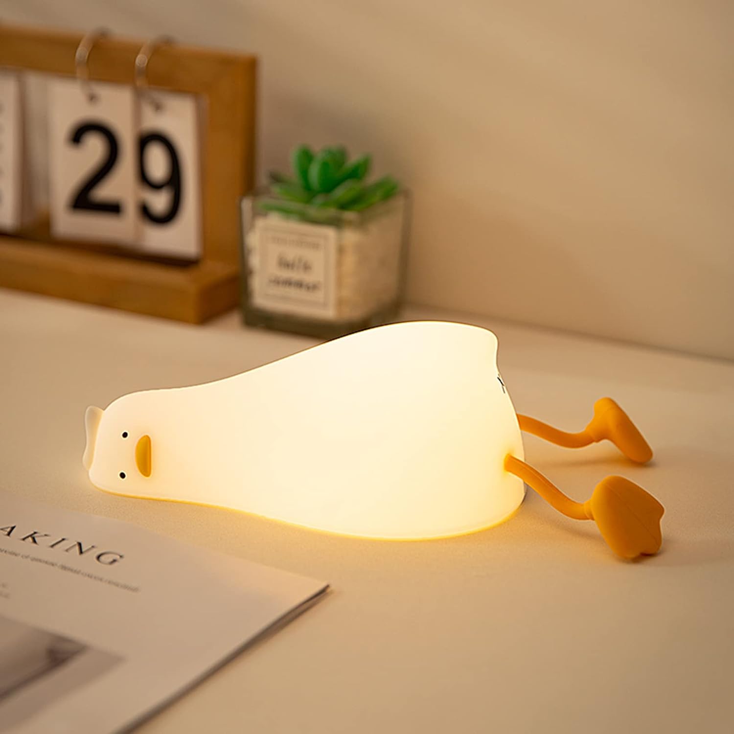 Lamp shaped like duck lying on its side on a desk