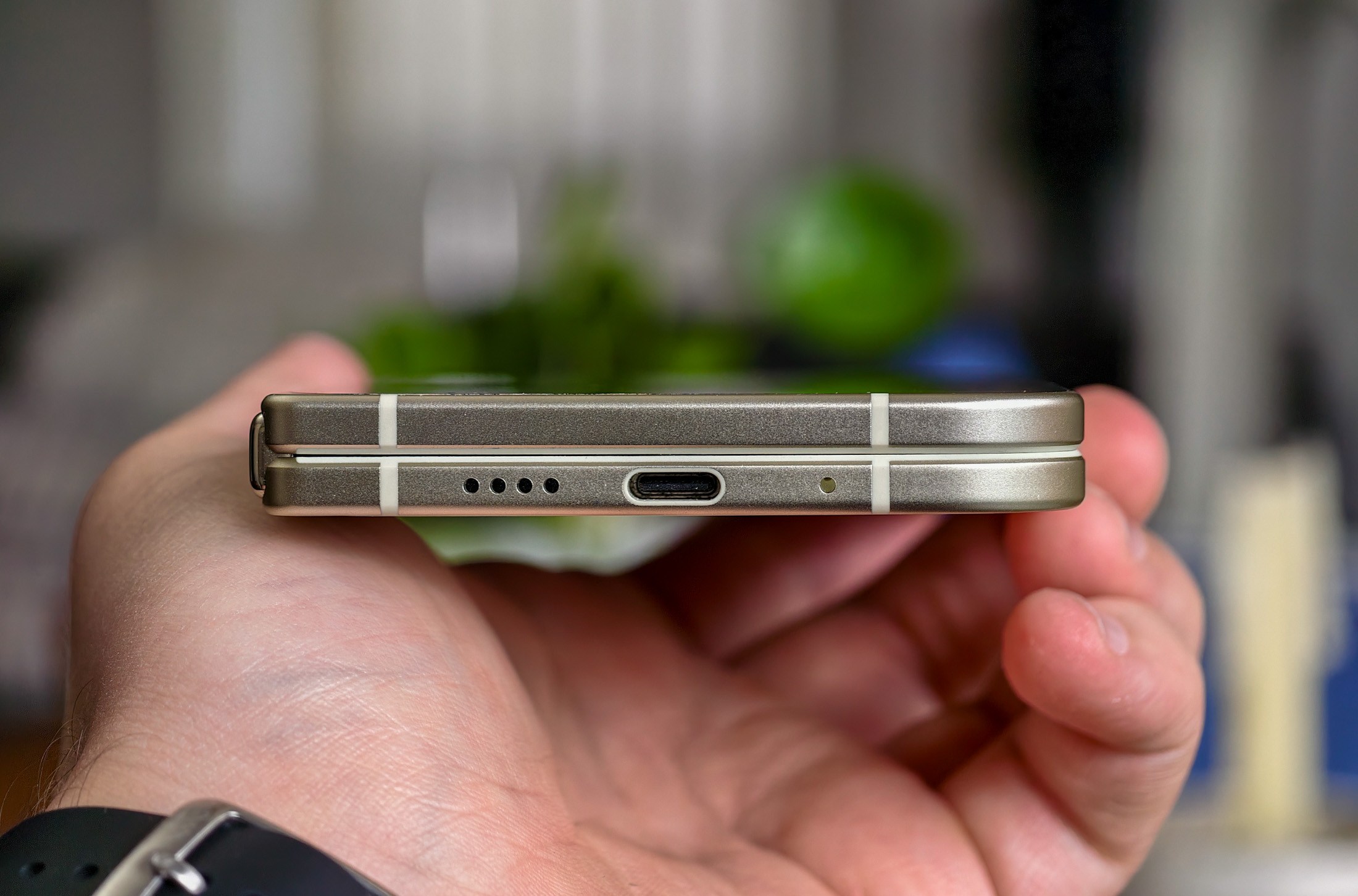 Google Pixel 10 Pro Fold held in a hand, horizontal and closed, showing the phone’s thin edge