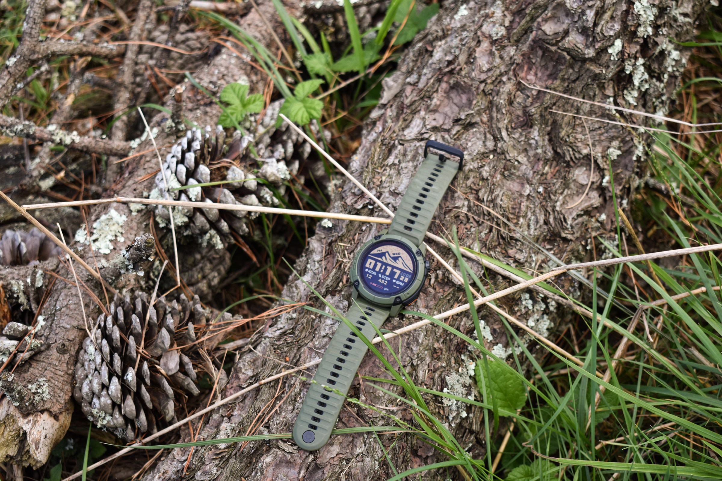 A Coros Nomad Watch rests on a fallen log