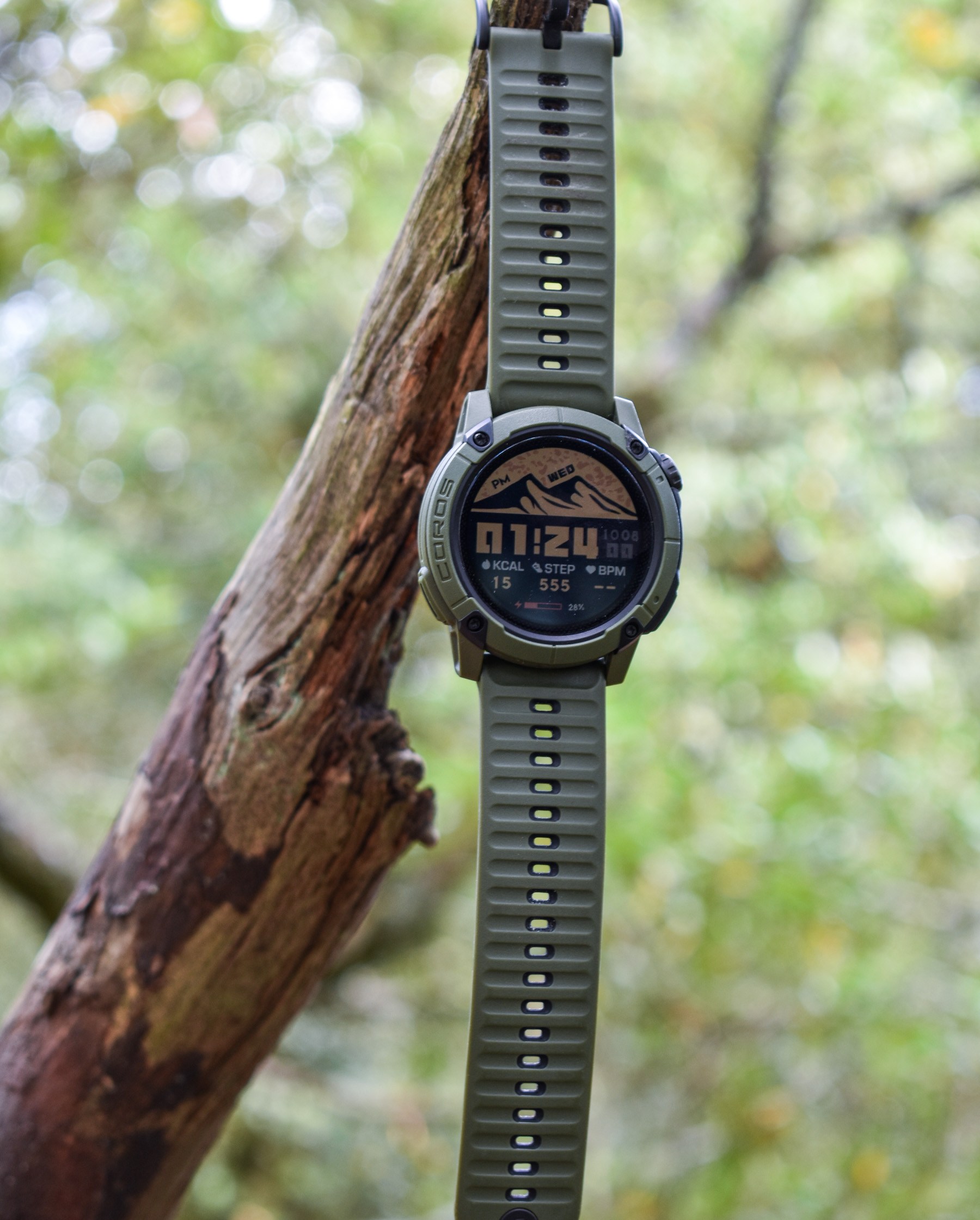 A Coros Nomad hangs from a tree branch